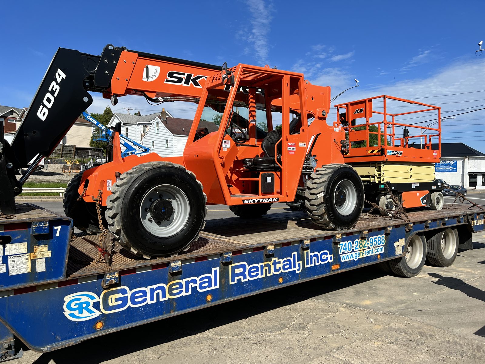 SkyTrak 6034 telehandler and JLG scissor lift loaded on a General Rental delivery trailer